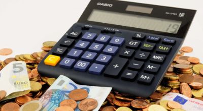calcolatrice con monete, tariffe euro spesa